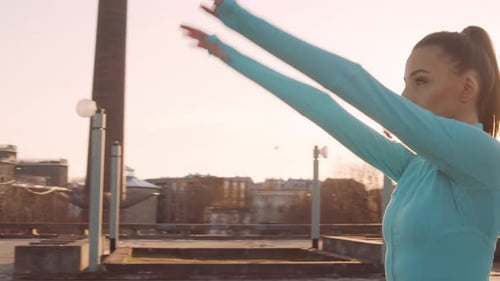 Woman Stretching Arms on Urban Rooftop