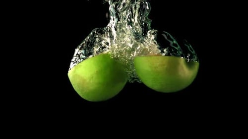 Super Slow Motion Two Halves of Apple Fall Under the Water with Air Bubbles