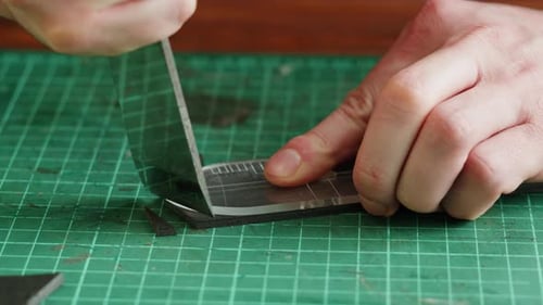 Craftsperson Cutting Foam with Template and Blade