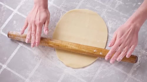 Woman Rolling Dough With Wooden Rolling Pin
