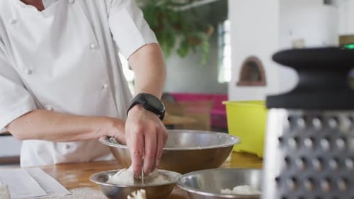 Caucasian female chef adding flour into a bowl