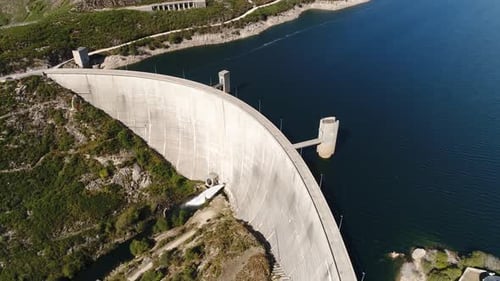 Modern Dam Reservoir on Blue Lake Waters Generate Alternative Energy in Highland Wild Area