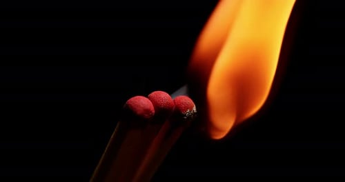 Burning Matches Ignite in a Dark Close-up