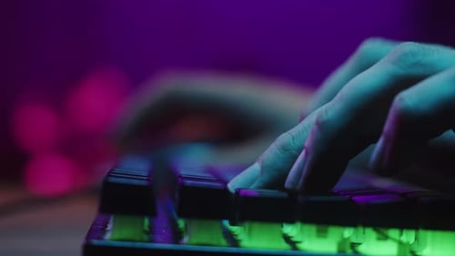 Gamer Typing on Backlight Keyboard Closeup Man Playing Video Game
