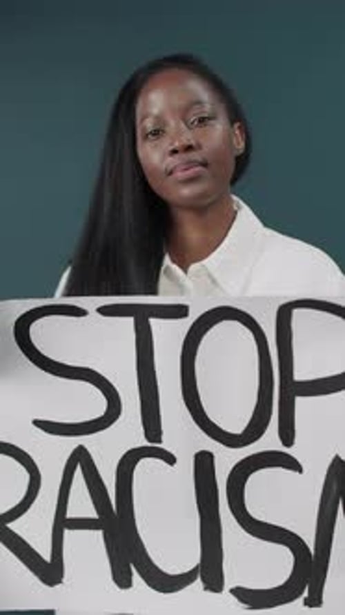 Young Woman Holds a Stop Racism Sign