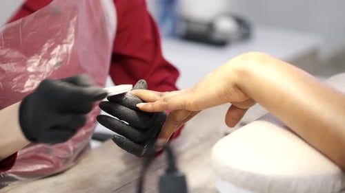 Manicurist Filing Nails in Beauty Salon