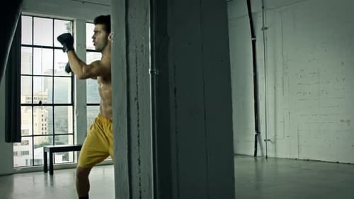 Man Boxing a Punching Bag in a Gym