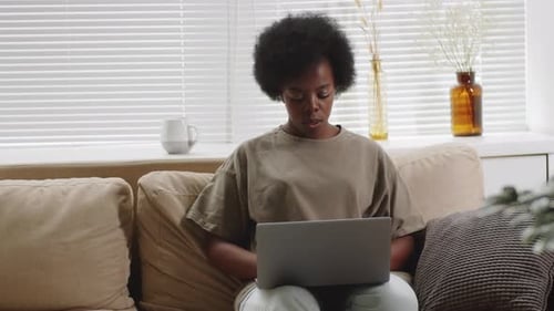 Woman Works on Laptop in Bright Living Room