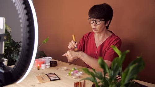 Atractiva bloguera envejecida hace reseñas de productos de belleza para un blog de vídeo da consejos a