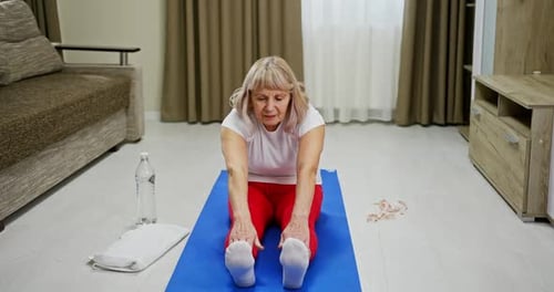 Woman Stretching toward Toes for Exercise at Home