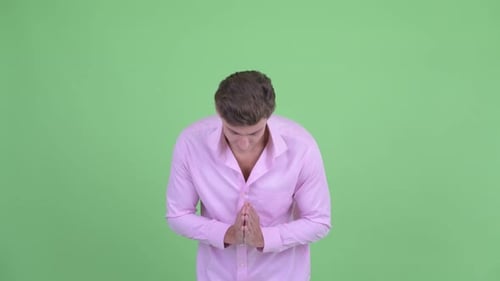 Young Adult Man Holding Hands Together and Smiling