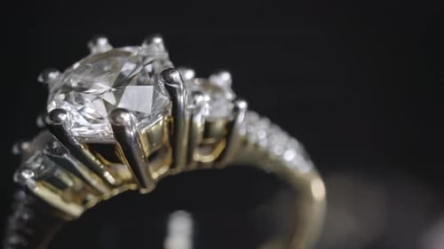 Gros plan extrêmement détaillé de la bague en diamant lors de la rotation sur fond sombre