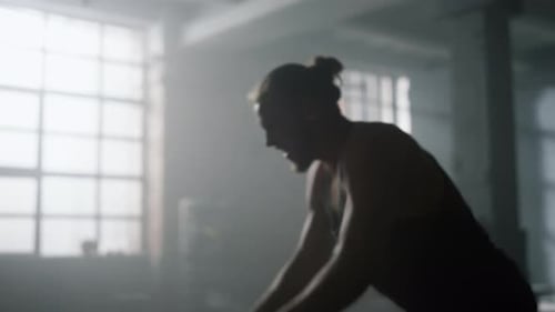 Man Working Out with Battle Ropes in Gym