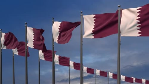 Waving Qatar Flags Against Blue Sky