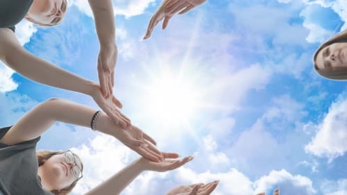 Friends Make a Circle From Their Palms Against the Background of a Fabulous Sky
