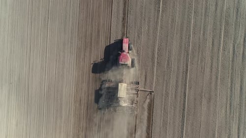 Countryside and Agriculture, Farm Tractors Plow the Earth in Field, Dust in the Field, View From