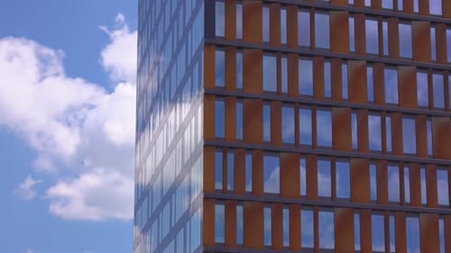 Modern Geometric Skyscraper Against Blue Cloudy Sky