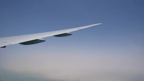 ein Flugzeugflügel mit den Wolken. Fracht- und Passagierluftverkehr. Flug mit dem Flugzeug