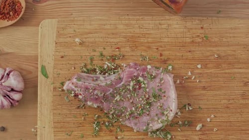 Seasoning Fresh Pork Chop with Herbs on Board