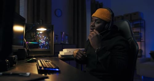 Young Adult with Headset Communicating and Coding Online