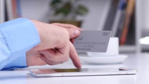 Man Shopping Online Using Digital Tablet and Credit Card. Close Up