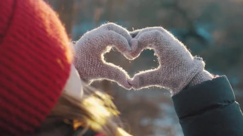 Winter Heart: Hands Forming Love Symbol in Snow