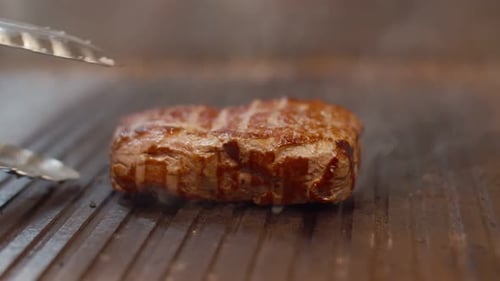 Delicious grilled beef fillet steak is laid out on the grill. Juicy grilled beef with aromatic spice