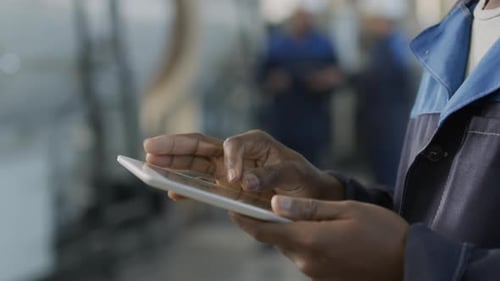 Unrecognizable Factory Worker Using Tablet