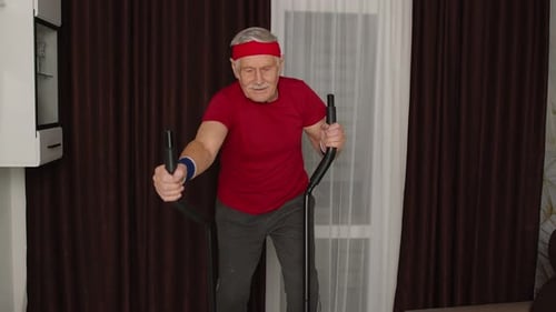 Senior Man Exercising on Elliptical Machine at Home