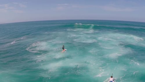 Aerial view of a man paddling while sup stand-up paddleboard surfing in Hawaii