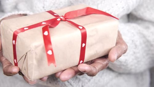 Senior Women Hand Holding a Gift Box Close Up