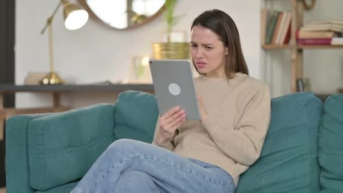 Woman Looks at Tablet with Confused Expression