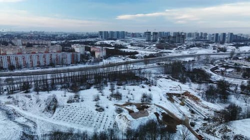 Flying in a suburban park. City blocks are visible. Winter cityscape.