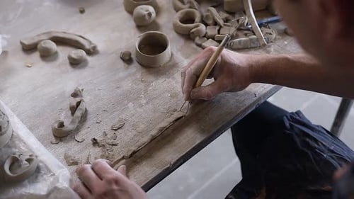Mains de potier masculin travaillant avec argile