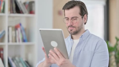 Portrait of Man in Glasses Using Digital Tablet
