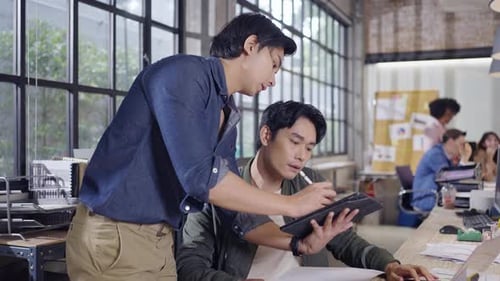 Men Working Together on a Tablet in an Office