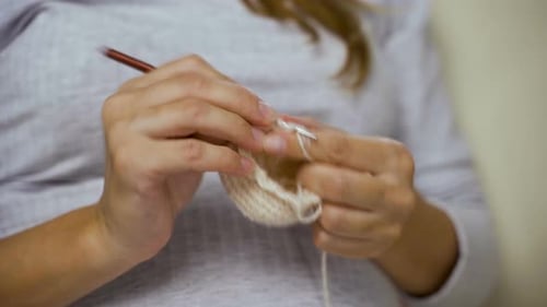 Woman Crocheting Carefully with Yarn and Hook