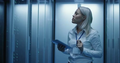 Female Technician Works on a Tablet in a Data Center