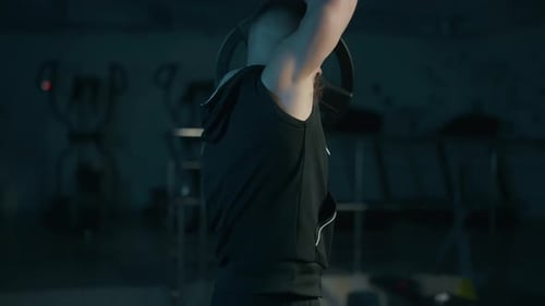 A Handsome Young Muscular Sportsman is Doing Exercise on a Fitness Machine in the Gym