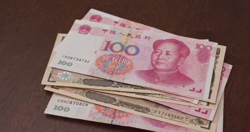 Stack of Yuan and Yen Banknotes Close Up
