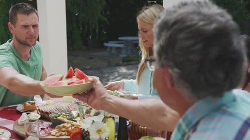 Family enjoys outdoor lunch together on bright day