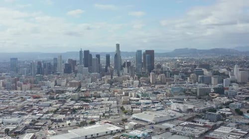 AERIAL: Slow Side Shot of Downtown Los Angeles Skyline with Warehouse Art District in Foreground