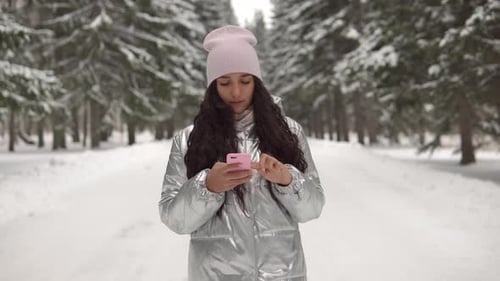 Attractive Girl in a Good Mood Walks Through the Winter Forest in the Afternoon