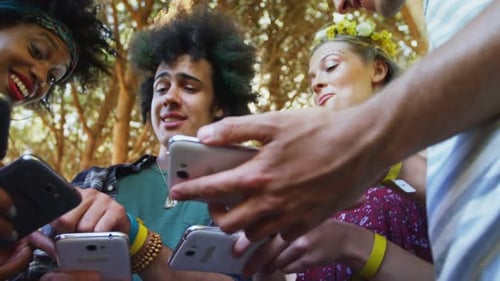 Friends interacting and using mobile phone in park 4k