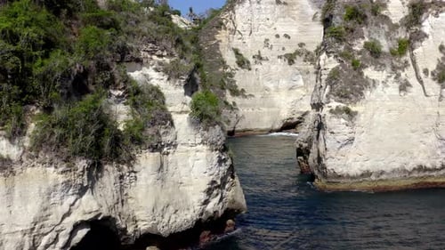 Nusa Penida island Diamond Beach in Indonesia revealing eroded rock formations, Aerial dolly in clos