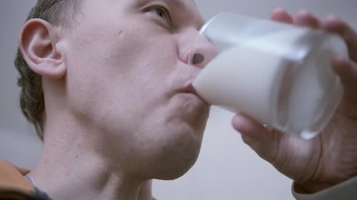 Man Drinking Milk From a Glass Glass Closeup