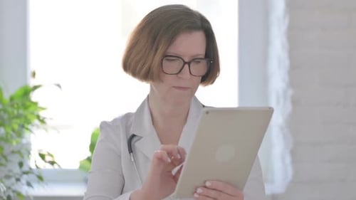 Senior Female Doctor Using Tablet in Office