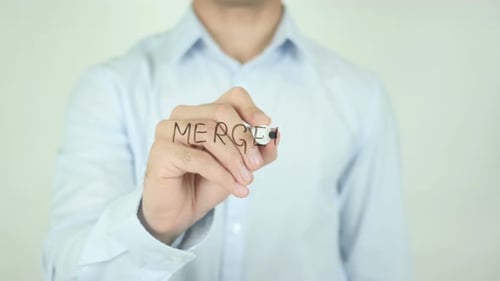 Man Writes Word Merger on Clear Surface