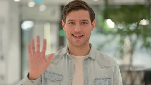 Portrait of Creative Young Man Waving Welcoming