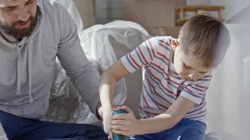 Father Teaches Son to Use a Drill